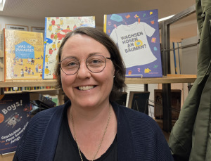 Mann steht im Raum uns spricht über ein projiziertes Bild an der Wand